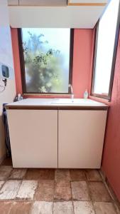a kitchen with a sink and a window at HomeStyle Agorà in Villasimius +15 photos