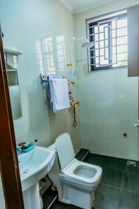 a bathroom with a white toilet and a sink at Bellevie Homestays in Uru +37 photos