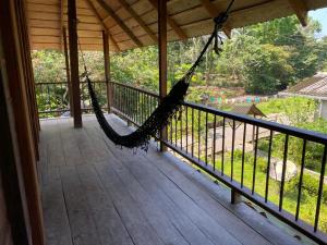 a hammock on the porch of a house at Cabaña los Termales in Nuquí