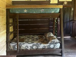 a wooden bunk bed with a pillow on it at Cabaña los Termales in Nuquí
