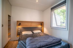 a small bedroom with a bed and a window at Cocon Marin dans Camping 5 étoiles in Vendres-Plage +29 photos