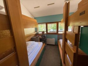 a boy standing in a room with bunk beds at Auberge de Jeunesse HI Annecy in Annecy