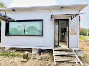 a small white building with a sign on the window at Datok homestay in Ban Khok Tarot