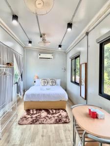 a bedroom with a bed and a table at Datok homestay in Ban Khok Tarot