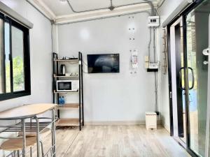 a room with a table and a tv on a wall at Datok homestay in Ban Khok Tarot