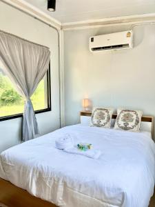 a bedroom with a white bed and a window at Datok homestay in Ban Khok Tarot