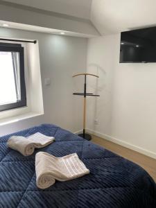 ein Schlafzimmer mit einem blauen Bett mit Handtüchern darauf in der Unterkunft Castle House in Palmela