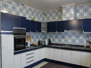 cocina con azulejos azules y blancos en la pared en Bed and Breakfast Colom, en Cambrils