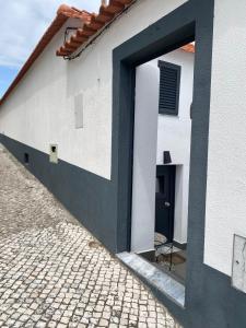 eine Tür zu einem weißen Gebäude mit einer schwarzen Tür in der Unterkunft Castle House in Palmela