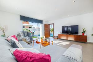 ein Wohnzimmer mit Sofa und Fernseher in der Unterkunft Llevantpicafort in Santa Margalida