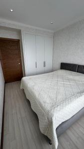 a bedroom with a large bed and a wooden floor at Issyk-Kul Novel in Korumdy
