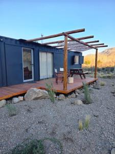 a blue house with a deck and a bench at Puesto El Arroyito in Tunuyán