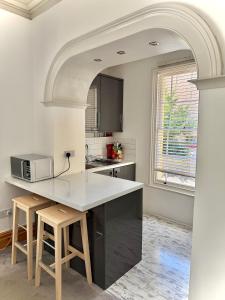 a kitchen with a counter with a microwave and stools at Entire Apartment by City Centre & Harbourside in Bristol