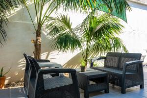 eine Terrasse mit Stühlen, einem Tisch und Palmen in der Unterkunft Llevantpicafort in Santa Margalida