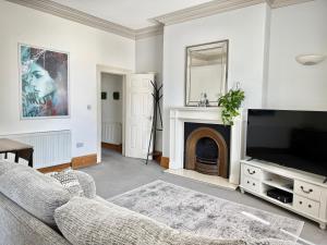 a living room with a couch and a tv and a fireplace at Entire Apartment by City Centre & Harbourside in Bristol