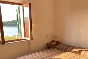 a bedroom with a bed and a window at Appartamenti Casa Gemma - Goelba in Procchio