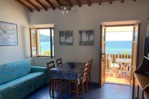 a living room with a table and a couch at Appartamenti Casa Gemma - Goelba in Procchio