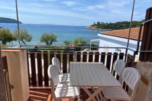 a table and chairs on a balcony with a view of the ocean at Appartamenti Casa Gemma - Goelba in Procchio