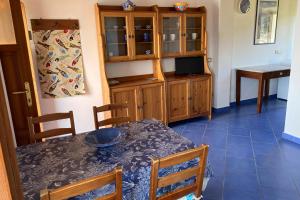a dining room with a table and wooden cabinets at Appartamenti Casa Gemma - Goelba in Procchio