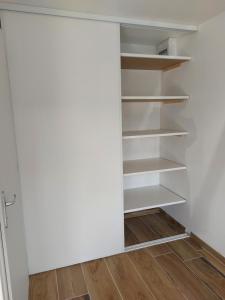 a closet with white shelves and a wooden floor at La Loge du Capitole in Veyrier-du-Lac