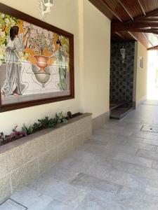 a hallway with a painting of a woman with a vase at Casa de Férias Alfena in Alfena