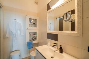 a white bathroom with a sink and a mirror at The Lodge Salento - San Foca in San Foca
