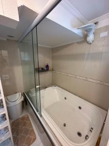 a bathroom with a bath tub and a toilet at Apartamento com Hidromassagem próximo a praia da enseada in Guarujá +20 photos