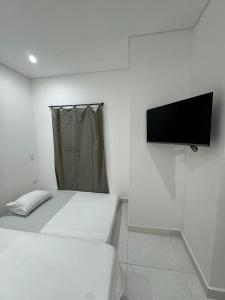 Una habitación con dos camas y un televisor de pantalla plana. en Habitaciones en Doradal 202, en Doradal