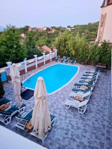a pool with chaise lounge chairs and a bunch ofvisorvisor at City view & pool apartment 2 in Niš