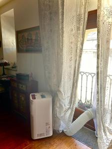 um quarto com uma janela com cortinas e um aquecedor em In the Heart of Turin em Turim