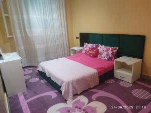 a bedroom with a bed with pink sheets and pillows at Mogadorista pour les familles in Essaouira