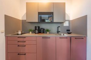 eine Küche mit rosa Schränken und einer Spüle in der Unterkunft Villa Carmen Strandkorb in Ahlbeck