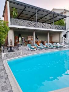 a swimming pool with chairs and a house at City view & pool apartment in Niš