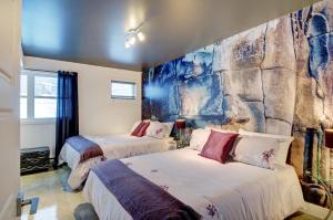 2 Betten in einem Zimmer mit einer Steinmauer in der Unterkunft Le Vallon in Saint-Férréol-les-Neiges