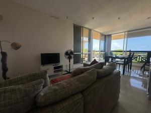ein Wohnzimmer mit Couch und Fernseher in der Unterkunft Appartement de la mer in Le Gosier