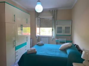 a bedroom with a blue bed and a window at Casa Granitto in Castello del Matese