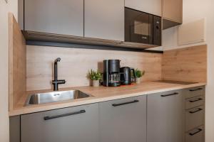 eine Küche mit Spüle und Mikrowelle in der Unterkunft Villa Carmen Sanddüne in Ahlbeck