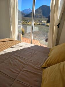 a bed in a room with a view of a mountain at Puesto El Arroyito in Tunuyán