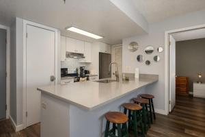 a kitchen with a white counter top and stools at Summit Unit 1103 in Granby +21 photos