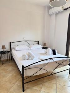 a bedroom with a bed with white sheets and towels at Alexis Apartments in Pylos