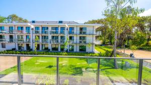 a large white building with blue windows at Ostseeresidenz Niechorze D208 Eco Boho - 5D Apartments in Niechorze