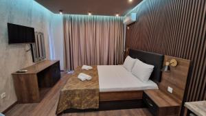 Cette chambre comprend un lit et une télévision. dans l'établissement MitProt Panorama Bay 2 luks Studio 143, à Sveti Vlas