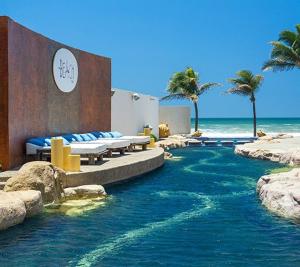 a resort with a swimming pool next to the ocean at Vidanta Villas Golf - Jacuzzi, Alberca, Lago in Acapulco