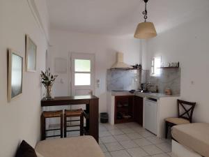 a living room with a kitchen and a table at Pension Hlias - Chora Amorgos in Amorgos