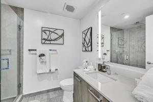a white bathroom with a sink and a toilet at Sunset Waterview Oasis Studio in Miami +9 photos