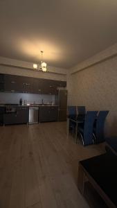 Una habitación grande con sillas azules y una cocina. en Family Accommodation, en Tiflis