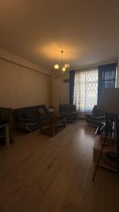 una sala de estar con un sofá y una mesa en Family Accommodation, en Tiflis