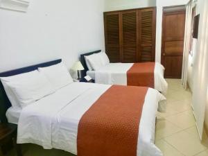 a hotel room with two beds in a room at Hotel La Plazuela in Popayan