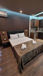 - une chambre avec un grand lit et des chaussons dans l'établissement MitProt Panorama Bay 2 luks Studio 143, à Sveti Vlas