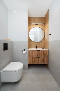 Manufaktura Suites - 76m2, Parking, AirCon - by Rentujemy في لودز: حمام به مرحاض أبيض ومرآة